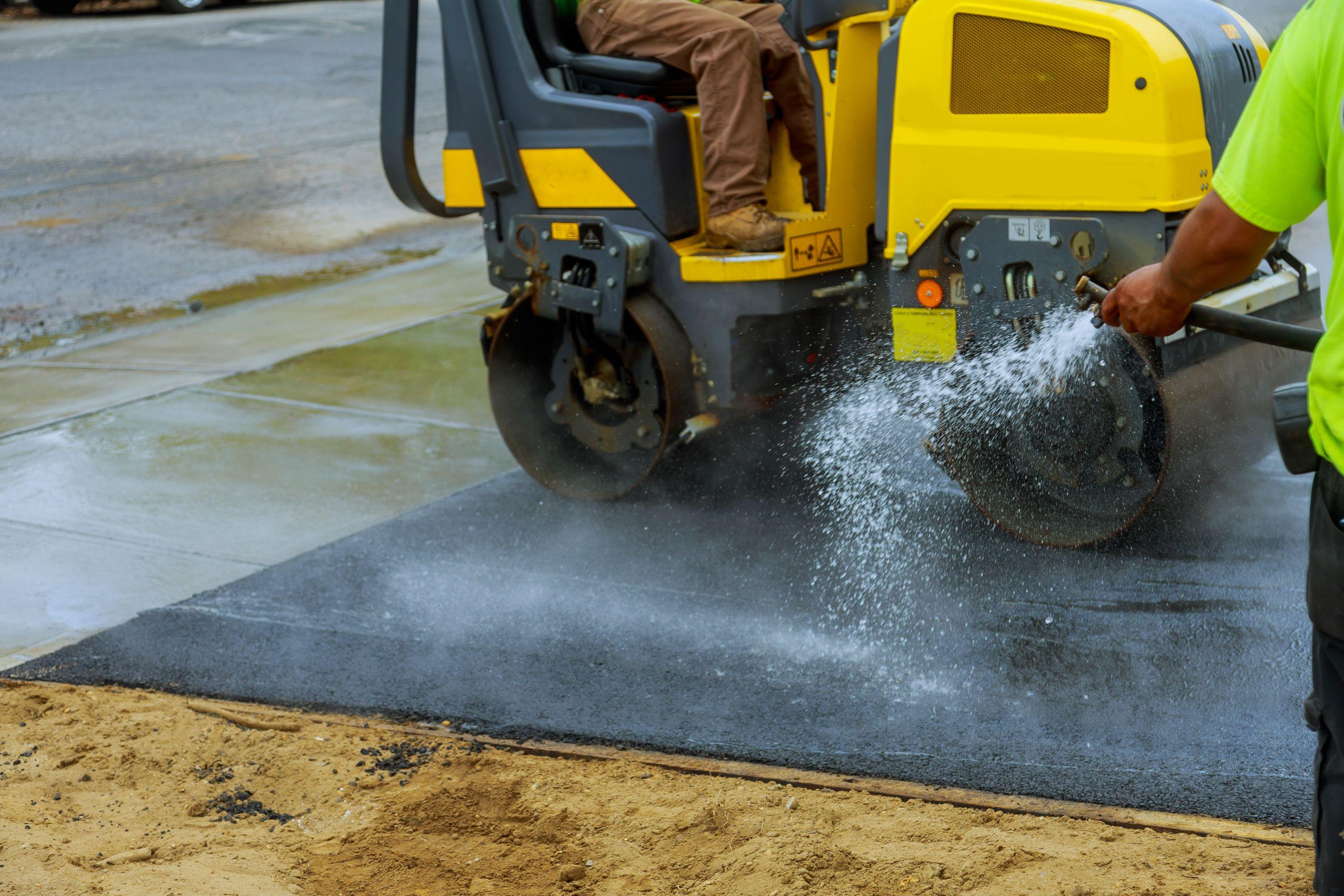 Road construction with roller compactor